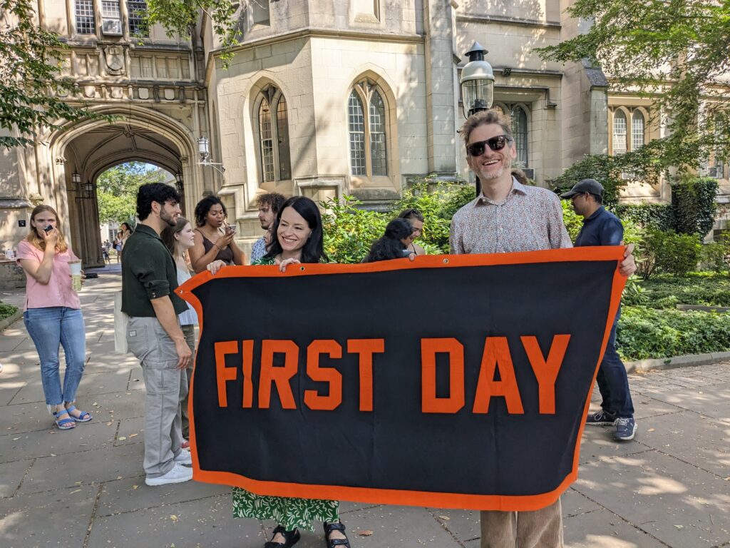Fellows Alice Marwick and Benjamin Mako Hill are wrapped in a First Day of school banner on campus.